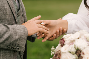 Obraz na płótnie Canvas The bride and groom exchange wedding rings, close-up