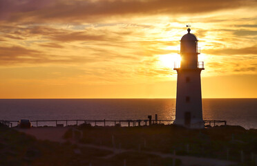Lighthouse at sunset at the sea landscape 