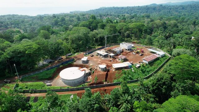 Aerial view around a water treatment facility, under construction, in sunny Sao Tome, Africa - orbit, drone shot