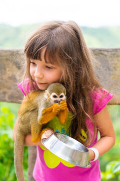 A Girl Feeds A Saimiri Monkey In The Dominican Republic. Excursion To Monkey Land, Monkey Park