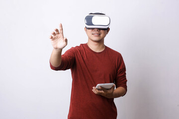 Asian man in casual style using Virtual Reality glasses and ipad is making movement, studio shot, mock up branding and copy space for creative advertisement designer