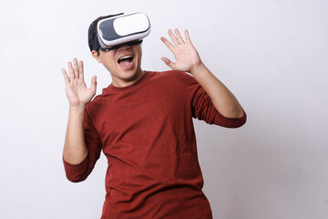 Attractive Asian man in casual style using Virtual Reality glasses and smart phone is feeling surprised, studio shot, mock up branding and copy space for creative advertisement designer