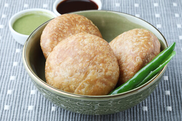 Kachori, green chilly and onion slice in plate. kachori is a spicy snack from India also spelled as...