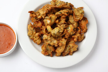 Fried onion pakora or Pyaj Pakoda also known as Crispy Kanda bhaji /Bhajji / bajji, favourite Indian Tea-Time snack during the rainy season. served with tomato ketchup