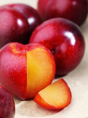 sweet, juicy plums with a plum slice on a white background
