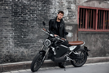 Obraz na płótnie Canvas Biker with modern motorcycle having a break in the city.