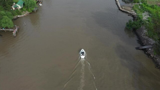 Drone tracking a single speed boat sailing waterway in tropical place