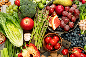 Delicious raw fruits and vegetables on light background.