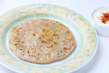 Traditional Indian food Aloo paratha or potato stuffed flat bread. served with curd