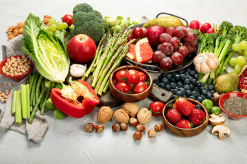 Delicious raw fruits and vegetables on light background.