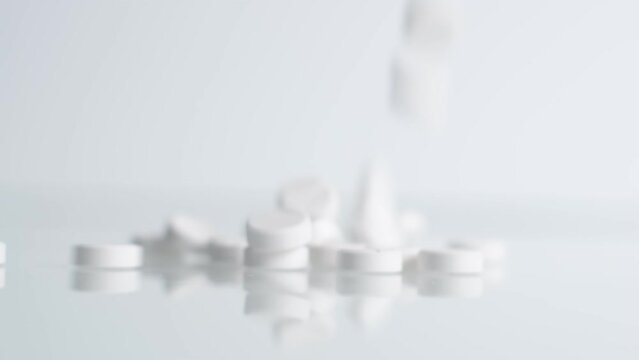 White falling pills. Medicine and healthy. Close up of capsules. Many white medical capsules falling down on the table. Closeup.