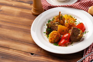 Beef meat stewed with potatoes on white plate