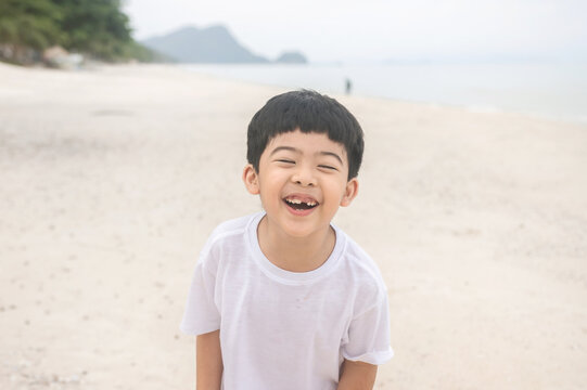 Portrait cute boy playing in the sandy beach, happy and Smiling child.
