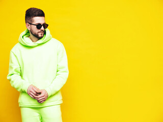 Portrait of handsome confident model. Sexy stylish man dressed in yellow hoodie with no logo. Clothes branding mockup. Design template for casual sportswear. Fashion male isolated  in studio