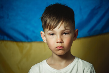 portrait of a boy on the background of the flag of Ukraine