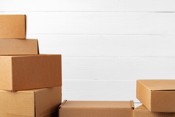 Group of cardboard boxes against white wooden wall