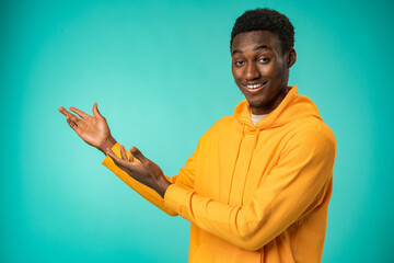 Happy African American man pointing finger at copy space