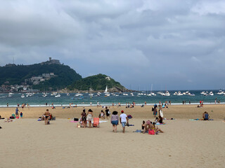 Obraz premium People enjoying summer day at San Sebastian beach La Concha in Basque Country