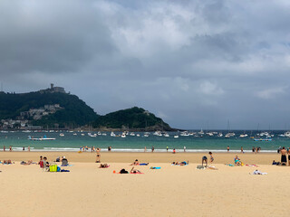 Obraz premium People enjoying summer day at San Sebastian beach La Concha in Basque Country