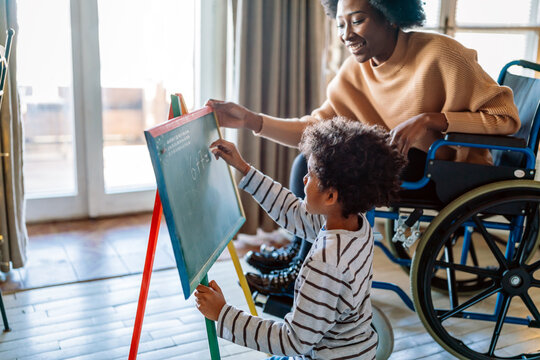 Happy child doing math exercises with her mother ot teacher together. Education people fun concept