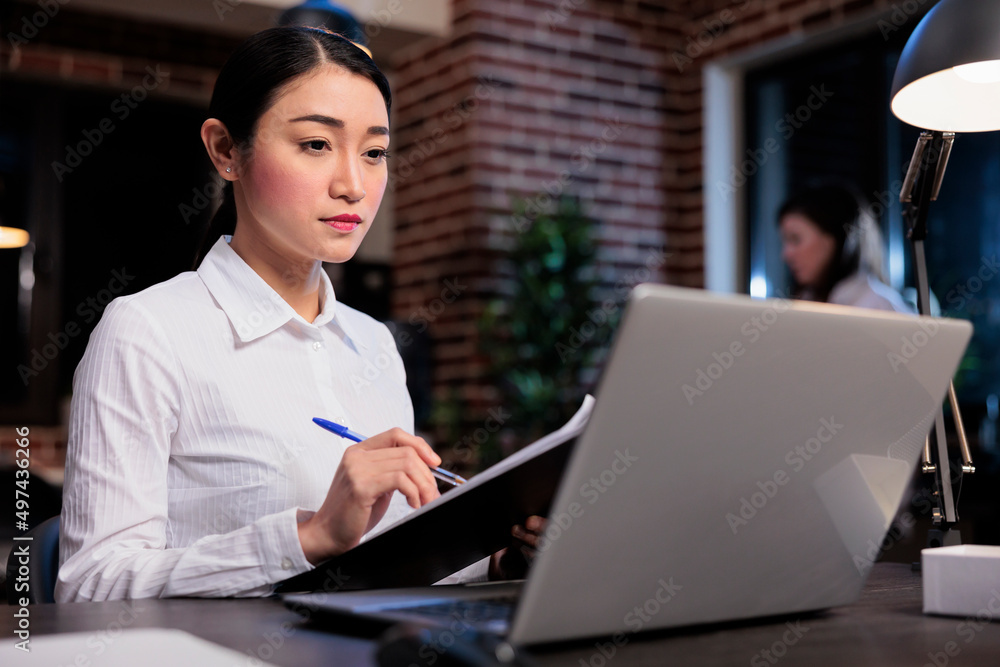 Poster Startup project manager sitting in office workspace while analyzing accounting data. Confident smiling businesswoman with documentation clipboard reviewing financial documents.