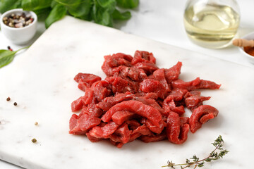 Uncocked Beef sliced meat, raw organic meat, beef strips. Small pieces of meat with pepper, dried herbs