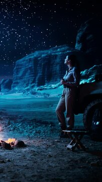 Vertical Video: Female Traveler Watching Night Sky while Camping in the Canyon by Campfire. Amazing Campsite view of Milky Way Stars with Traveling Woman Adventurer on Inspirational Journey