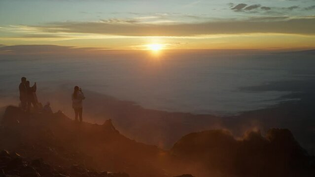 Tourist enjoying magical morning sunrise on top of active Arenal volcano, Costa Rica