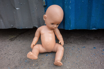 Image of poverty in a doll abandoned in the garbage. Concept of complete loneliness