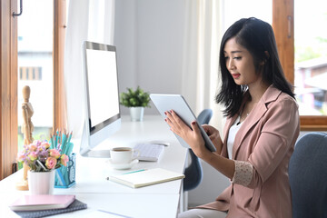 Obraz na płótnie Canvas Concentrated businesswoman checking information on digital tablet.