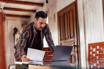 Man using a laptop, working from the home office.