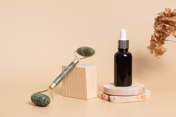 Dropper bottle with cosmetic oil and face massager on wooden podiums. Face care concept in rustic style