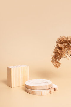 Wooden podium or pedestal for cosmetics, perfumes or jewelry. Neutral beige monochrome with dry flowers mok ap, blank