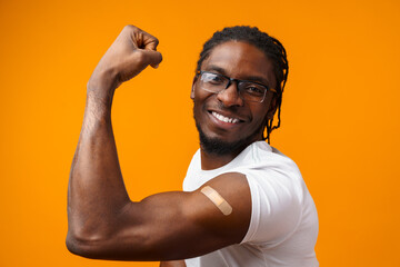Young black man got vaccinated from coronavirus against yellow background - obrazy, fototapety, plakaty