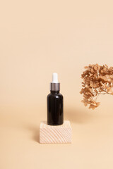Wooden podium or pedestal with a dropper bottle of cosmetics oil or serum. Neutral beige monochrome skin care concept
