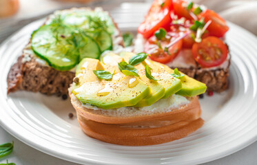 Feta sandwiches with avocado, cherry tomatoes and cucumber close-up.