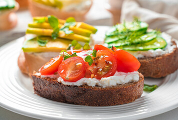 Sandwich with feta, cherry tomatoes, avocado and cucumber close-up.