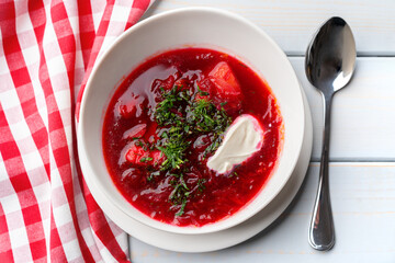 Bowl of beet root soup borsch on white wooden background