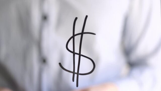 A hand writing a dollar sign on a window. For brainstorming - the concept of money