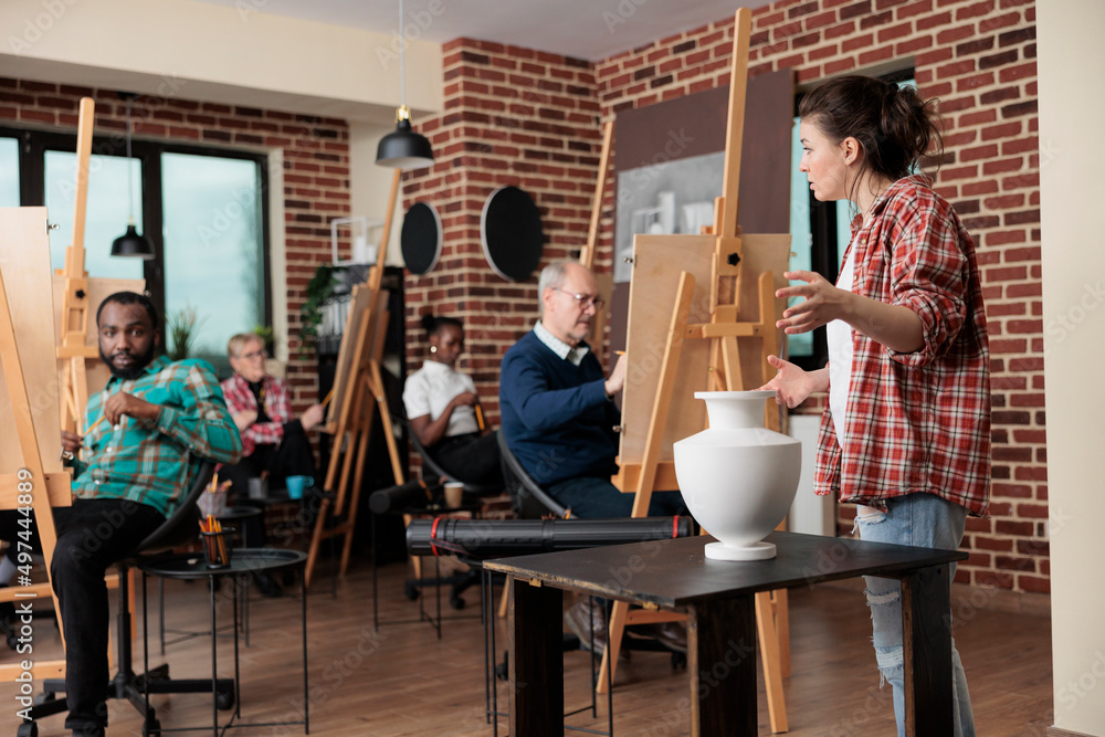 Poster painter teacher supervising senior man while drawing vase model on canvas working at illustration te