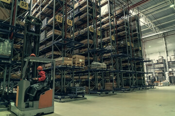 Warehouse of logistic company with forklifts. Large distribution storehouse with high shelves.