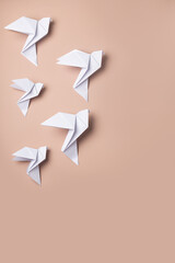 White dove origami as a symbol of peace on a pink background