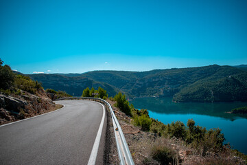 Obraz premium Paisaje con carretera y lago en un dia despejado