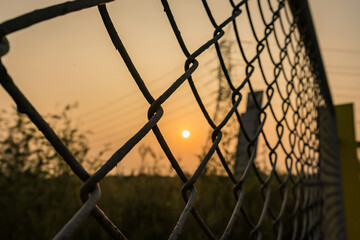 Looking thru the wire mesh steel to see the sunrire morning.