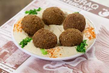 Falafel served on a plate of hummus 