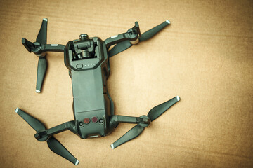 The compact plastic copter lies upside down on cardboard.The fallen copter. Drone crash.