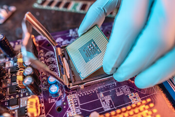 Engineer repairman holding hands CPU to insert into the socket of the motherboard. Technology...