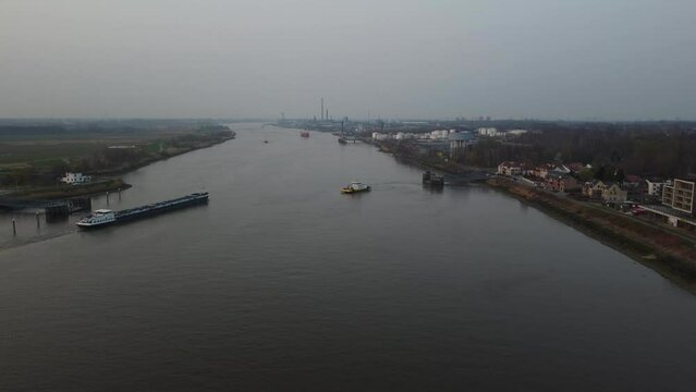 Boats moving in waterway of river Scheldt on moody day, aerial view