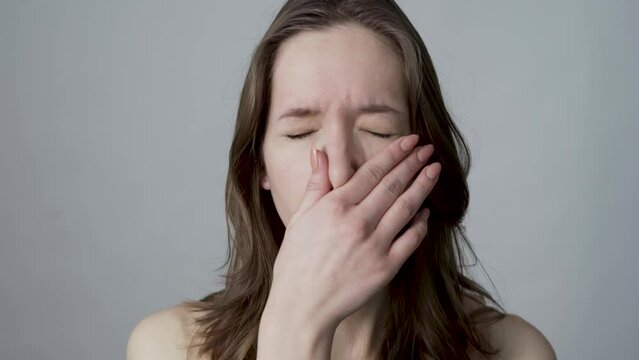young woman closes nose because of a bad smell
