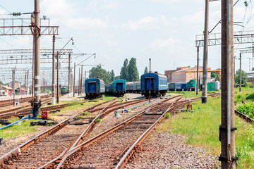 Fototapeta na wymiar Railway station with rails, buildings and trains in the distance